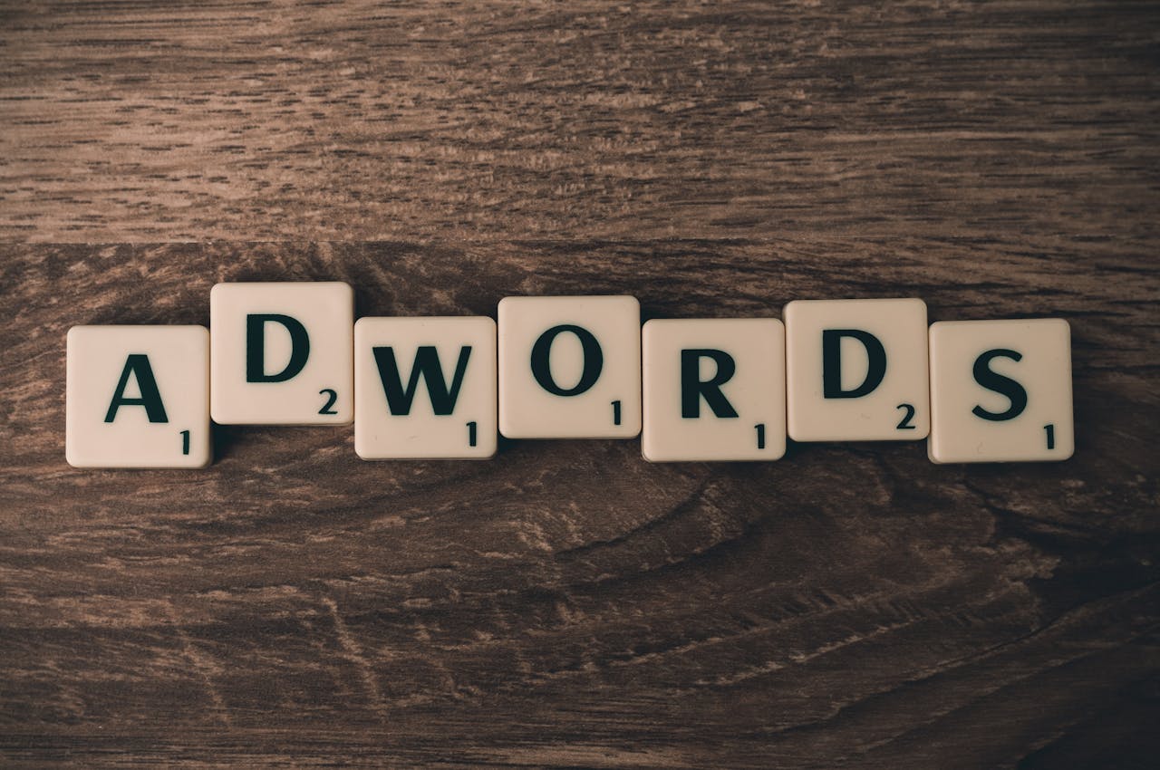 team-03 Scrabble tiles spelling 'AdWords' on a wooden surface, symbolizing digital marketing concepts.